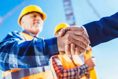 construction workers shake hands